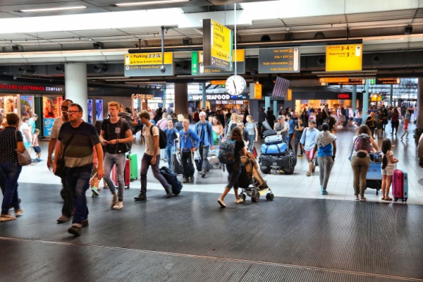 People rush through a busy, crowded airport.